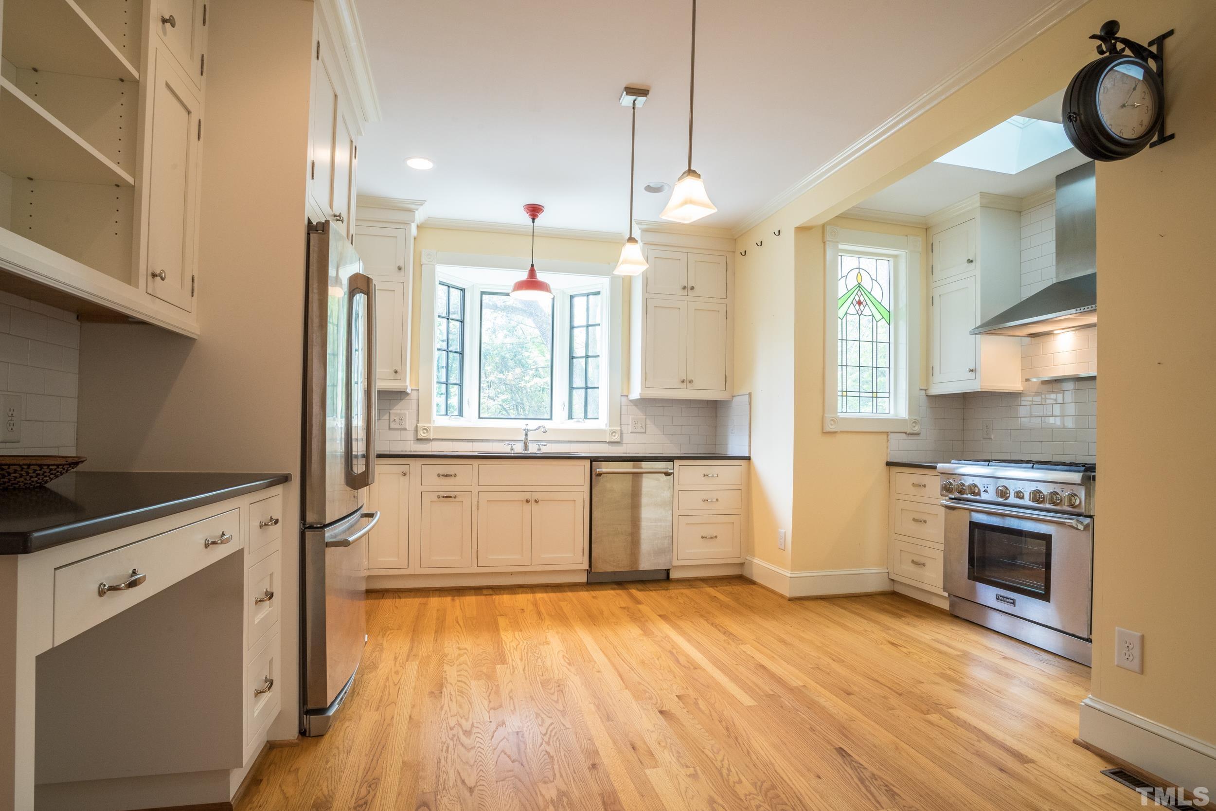 1903 Alexander Road Raleigh, NC 27608 - Photo 9 of 26 a kitchen with granite countertop a stove a sink and a refrigerator