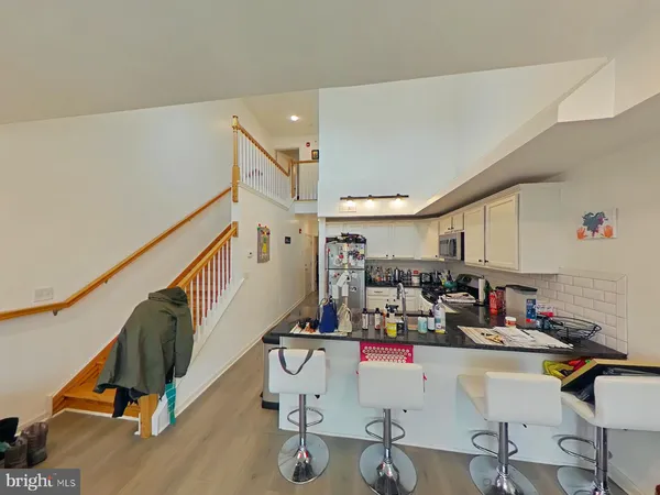 a room with lots of white furniture and wooden floors