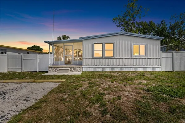a view of a house with a yard and potted plants