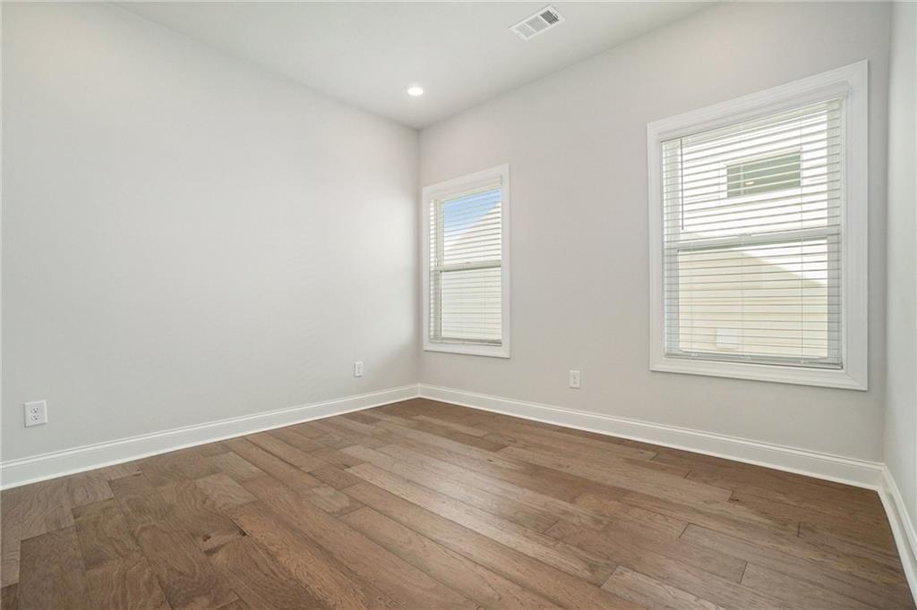 106 Basil Street Cumming, GA 30040 - Photo 10 of 25 an empty room with wooden floor and windows