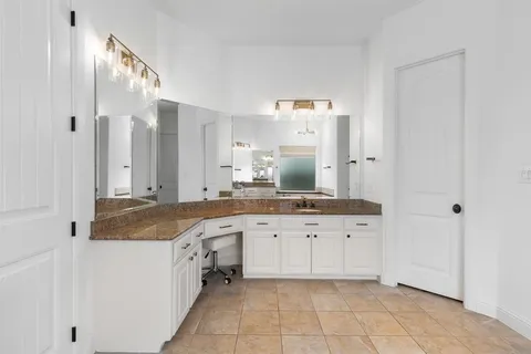 a spacious bathroom with a granite countertop double vanity sink mirror and