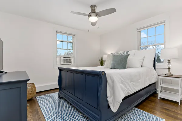 a bedroom with a bed wooden floor and window