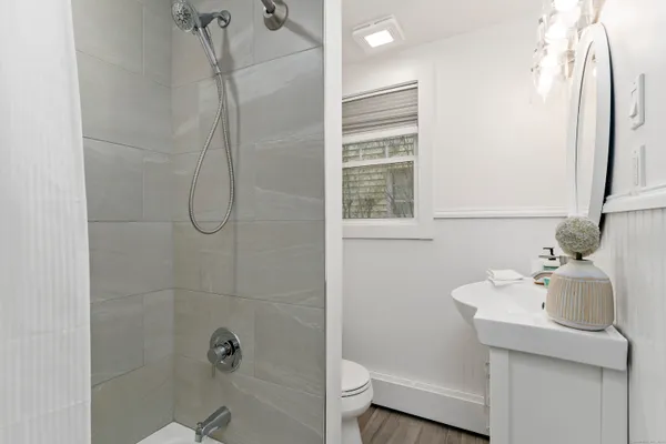 a bathroom with a sink a toilet and shower
