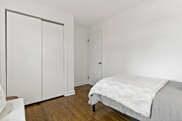 a bedroom with a bed and wooden floor