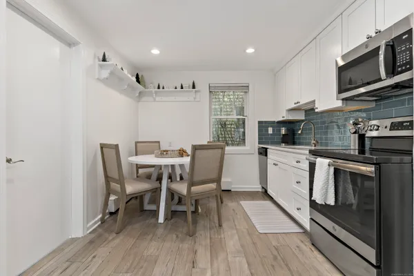a kitchen with a table chairs microwave and cabinets