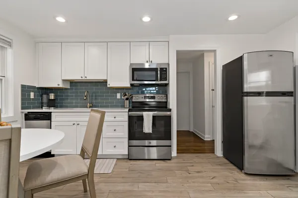a kitchen with stainless steel appliances a refrigerator stove microwave and cabinets