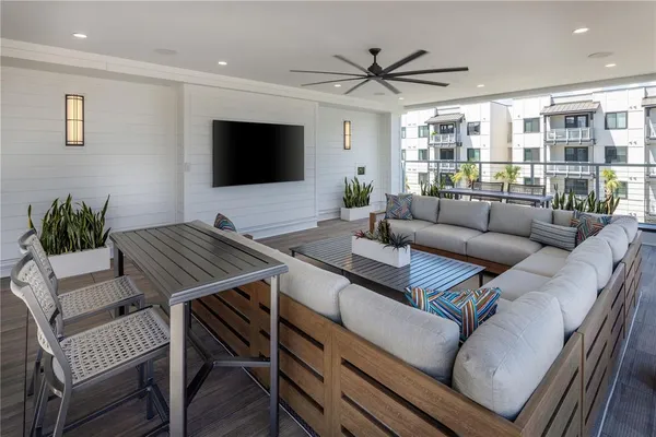 a view of a patio with couches table and chairs under an umbrella