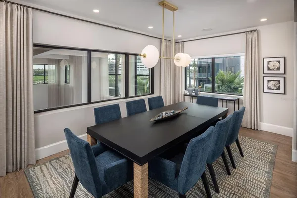 a kitchen with stainless steel appliances a dining table chairs stove refrigerator and microwave