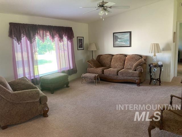 1095 County Road 70 Weiser, ID 83672 - Photo 12 of 44 Spacious interior featuring a large window, vaulted ceiling, ceiling fan, and carpeted flooring