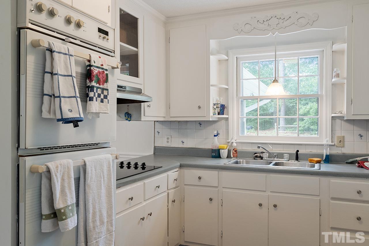6407 Amhurst Road Durham, NC 27713 - Photo 16 of 28 a kitchen with stainless steel appliances white cabinets and a window