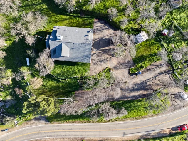 an aerial view of a house with a yard and potted plants