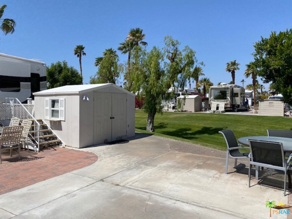 69801 Ramon Road, Unit 378 Cathedral City, CA 92234 - Photo 3 of 5 a view of a patio with table and chairs potted plants and a palm tree