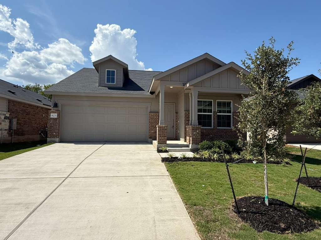 Craftsman house with brick siding, a front lawn, concrete driveway, an attached garage, and a porch
