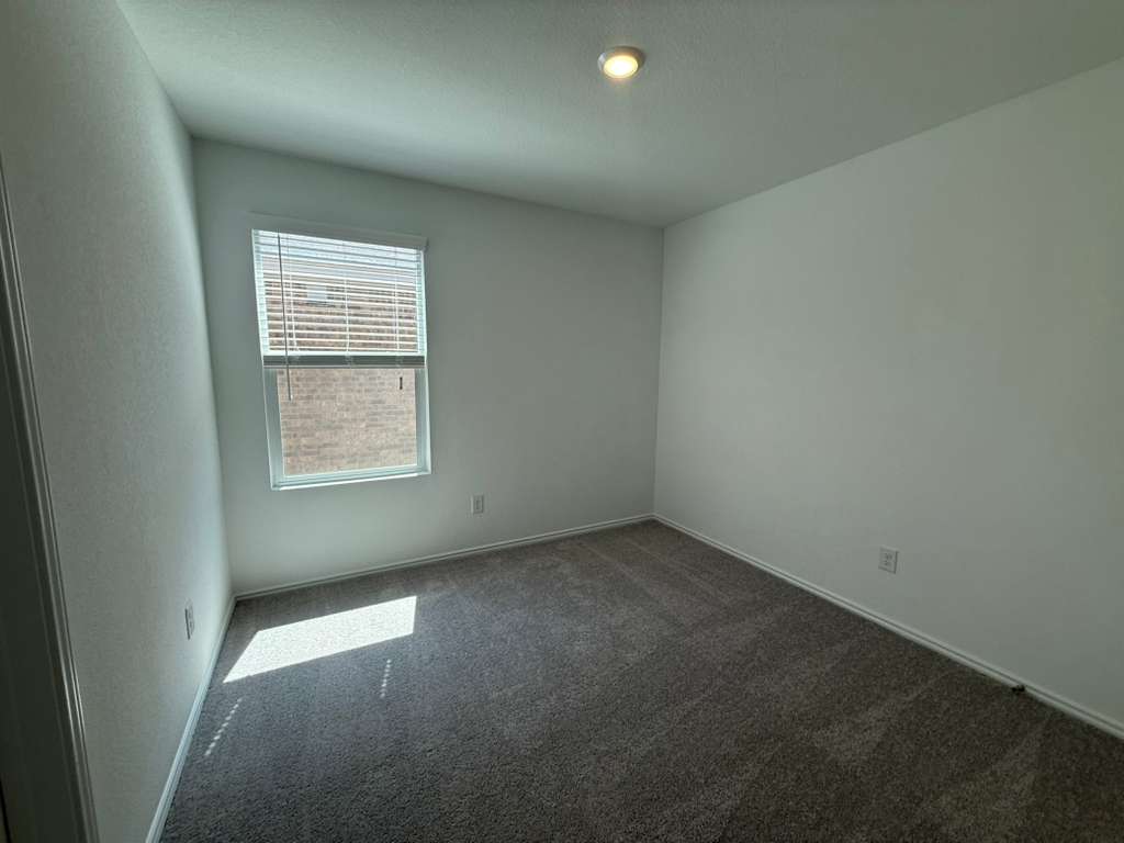 623 Sormonne Loop Kyle, TX 78640 - Photo 13 of 40 Spare room featuring dark colored carpet and baseboards