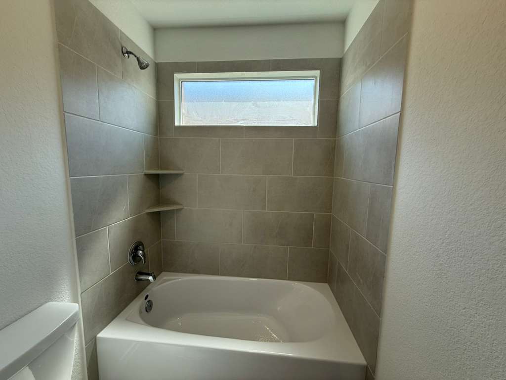 623 Sormonne Loop Kyle, TX 78640 - Photo 21 of 40 Full bathroom featuring a textured wall and bathing tub / shower combination