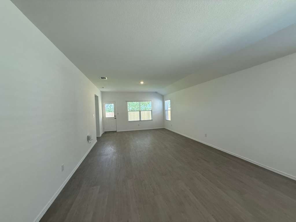 623 Sormonne Loop Kyle, TX 78640 - Photo 22 of 40 Empty room with dark wood-style floors and baseboards