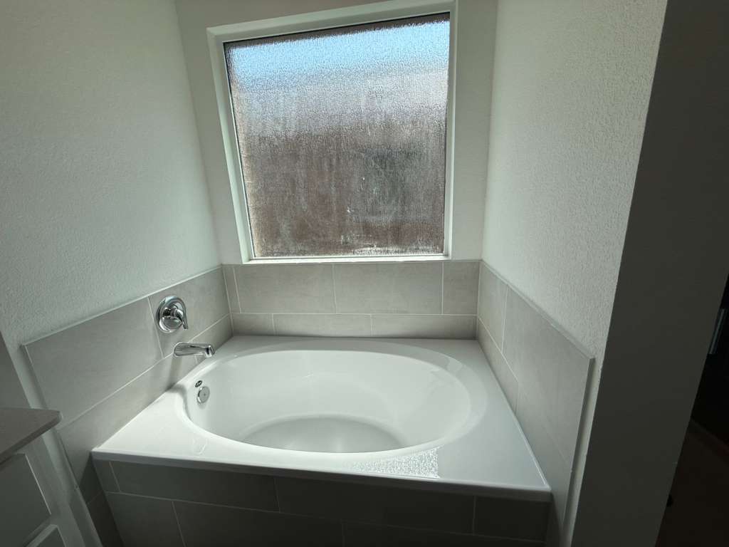 623 Sormonne Loop Kyle, TX 78640 - Photo 30 of 40 Full bathroom with a bath and a textured wall