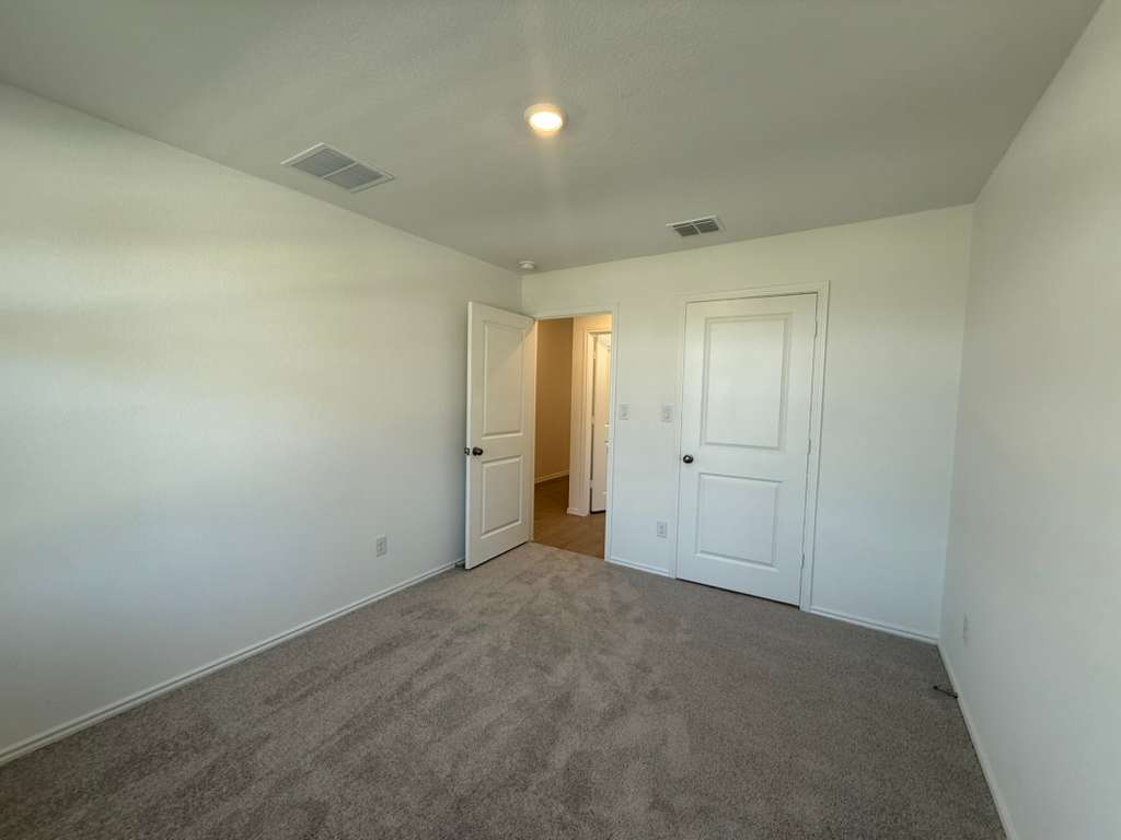 623 Sormonne Loop Kyle, TX 78640 - Photo 6 of 40 Unfurnished bedroom featuring carpet and baseboards