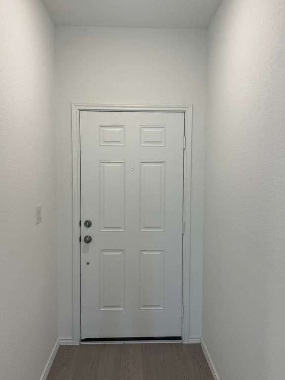 623 Sormonne Loop Kyle, TX 78640 - Photo 7 of 40 Doorway to outside with wood finished floors and baseboards
