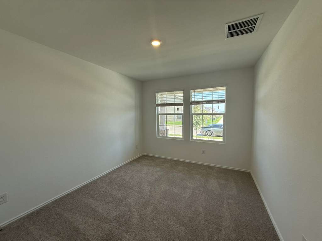 623 Sormonne Loop Kyle, TX 78640 - Photo 9 of 40 Carpeted empty room featuring baseboards and recessed lighting