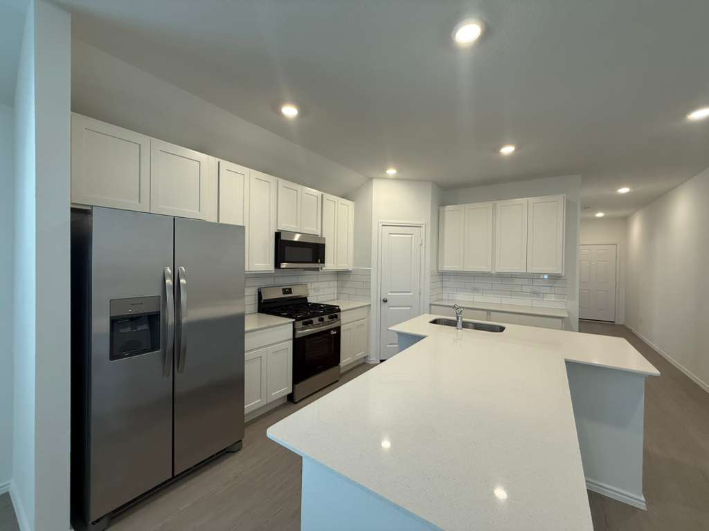 623 Sormonne Loop Kyle, TX 78640 - Photo 10 of 40 Kitchen featuring appliances with stainless steel finishes, white cabinetry, backsplash, and recessed lighting