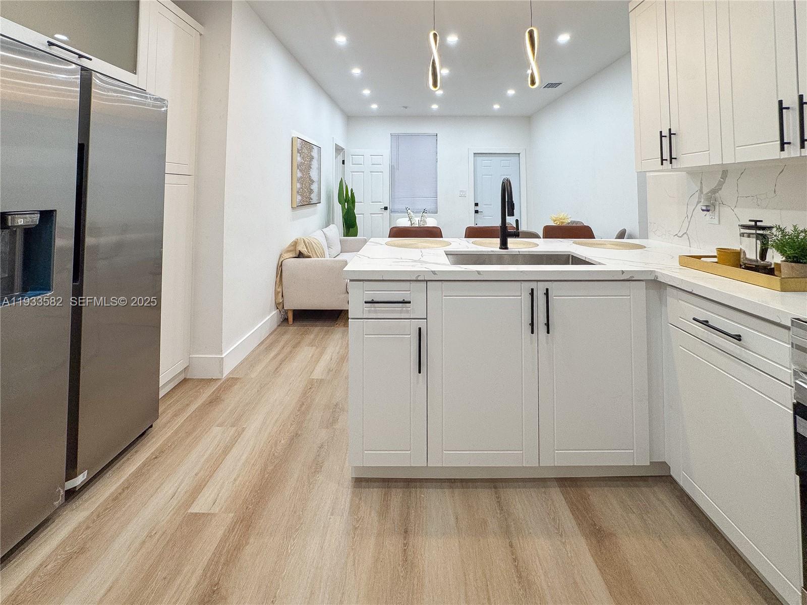 794 Northwest 44th Street Miami, FL 33127 - Photo 12 of 31 a kitchen with white cabinets and stainless steel appliances