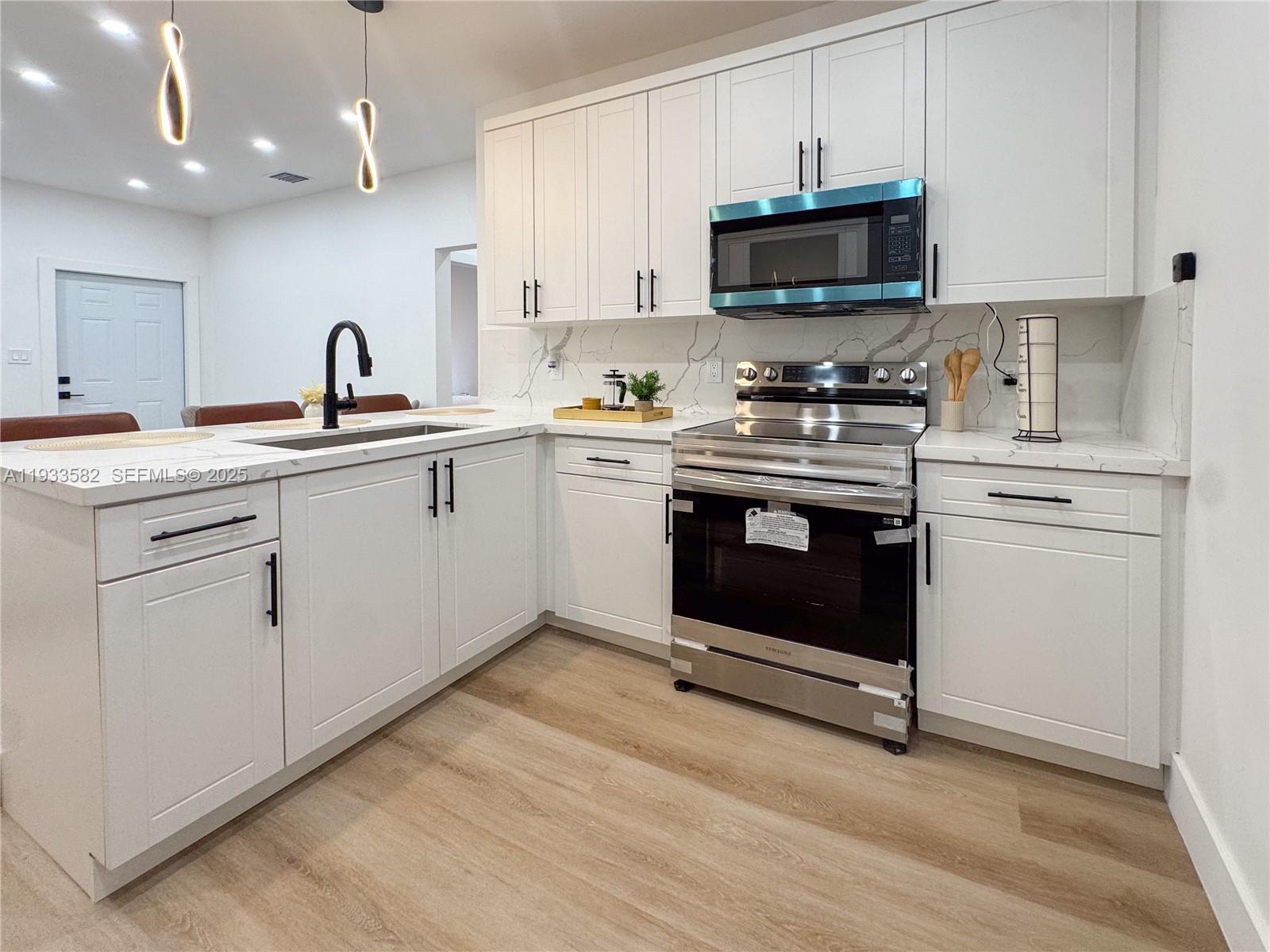 794 Northwest 44th Street Miami, FL 33127 - Photo 13 of 31 a kitchen with a sink stove and microwave