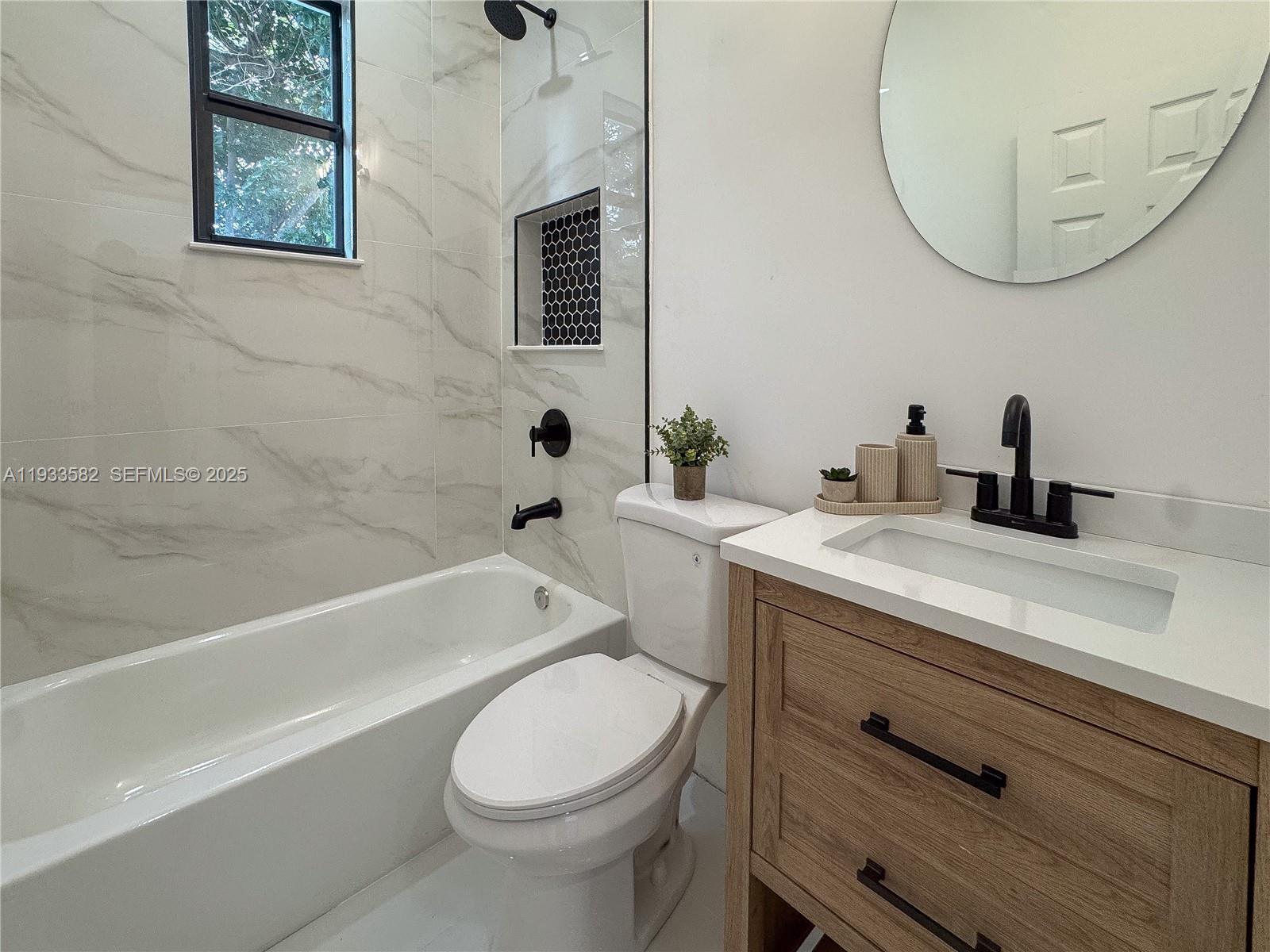 794 Northwest 44th Street Miami, FL 33127 - Photo 19 of 31 a bathroom with a sink a toilet and a mirror