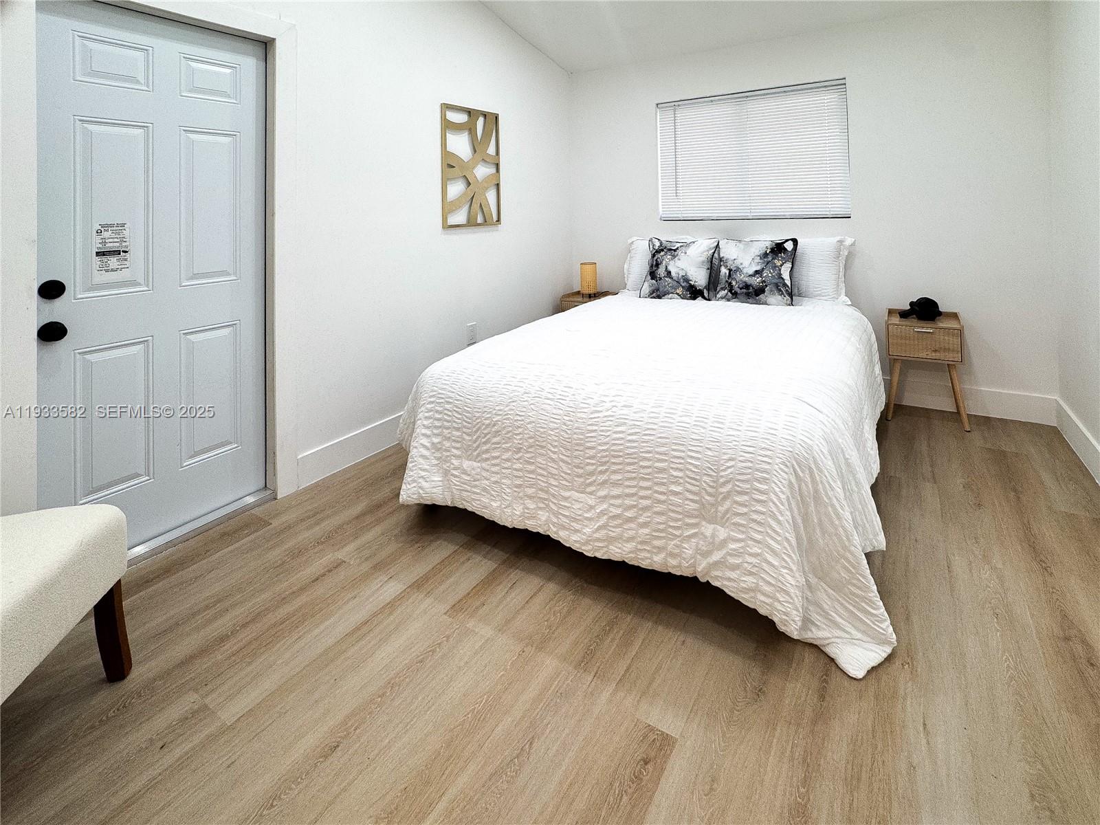 794 Northwest 44th Street Miami, FL 33127 - Photo 25 of 31 a bedroom with a bed and wooden floor