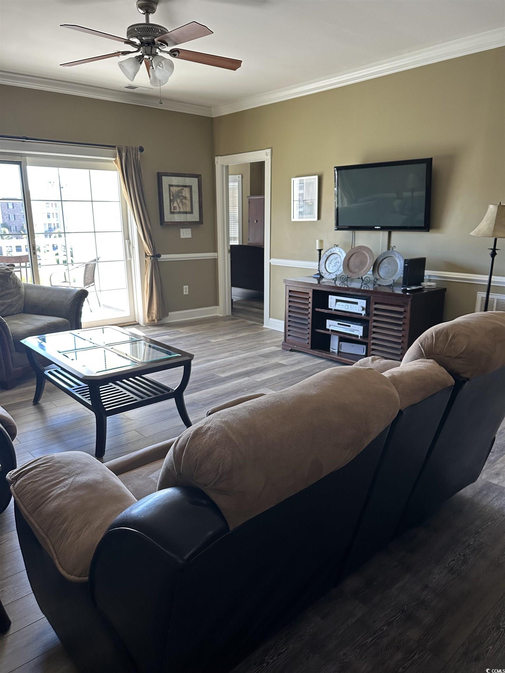 4811 Magnolia Lake Drive, Unit 302 Myrtle Beach, SC 29577 - Photo 8 of 39 Living area with crown molding, wood finished floors, and a ceiling fan