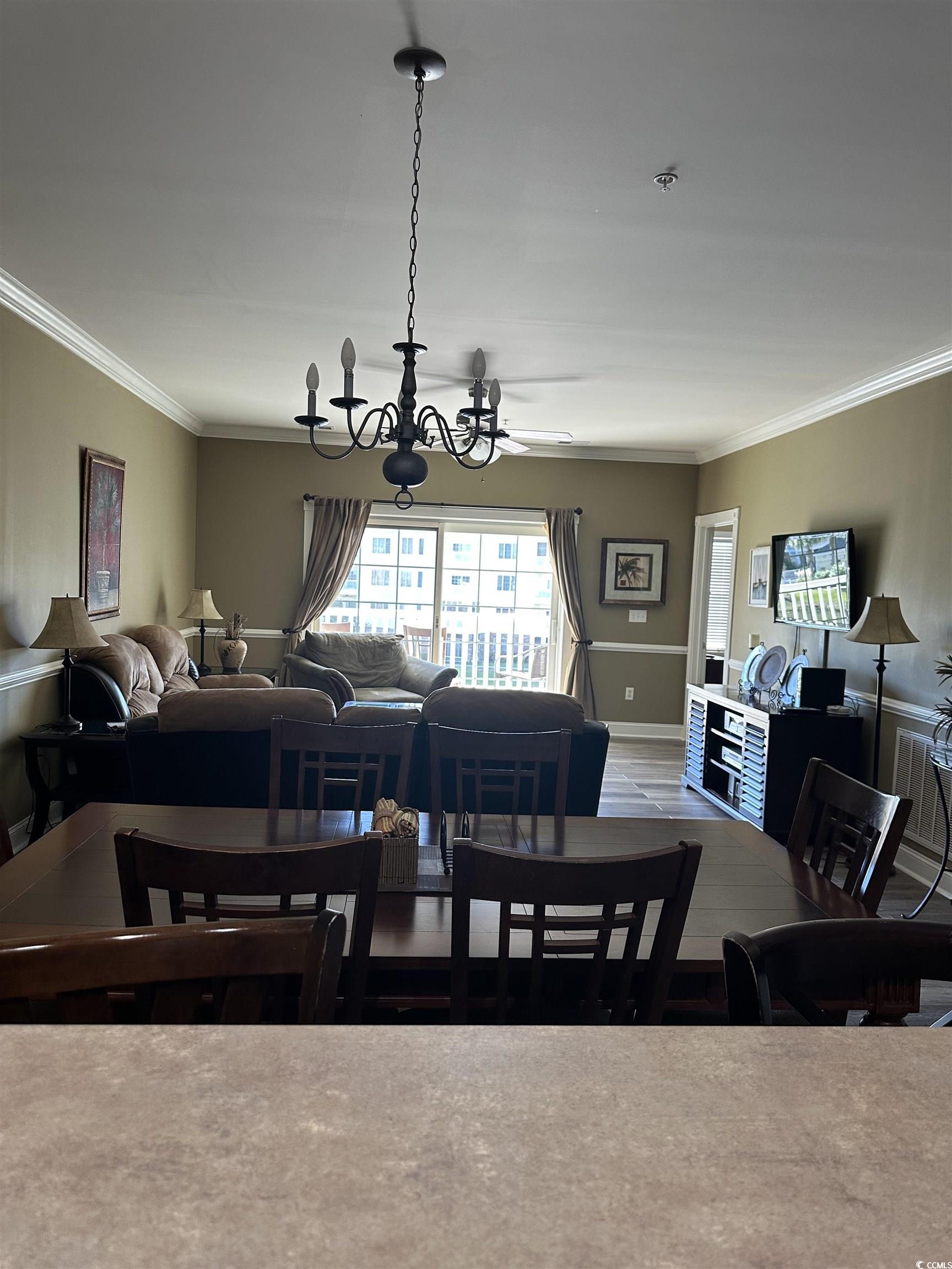 4811 Magnolia Lake Drive, Unit 302 Myrtle Beach, SC 29577 - Photo 10 of 39 Dining area featuring crown molding and a chandelier