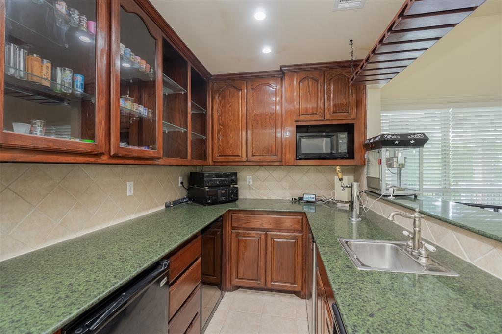 135 Kirkpatrick Road Ennis, TX 75119 - Photo 24 of 40 a kitchen with stainless steel appliances granite countertop wooden cabinets a sink and dishwasher
