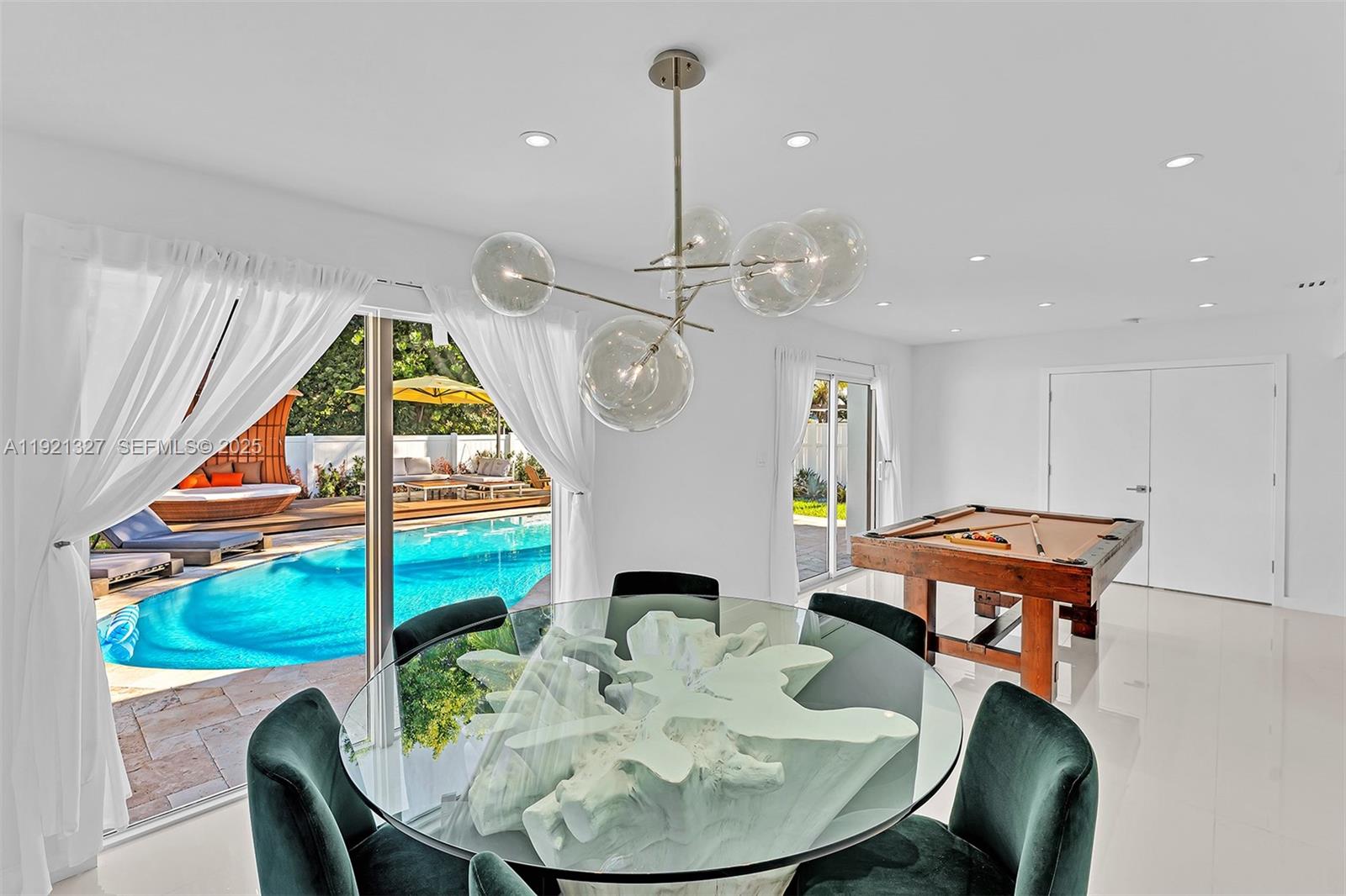 5005 Johnson Street Hollywood, FL 33021 - Photo 14 of 39 a dining room with furniture a chandelier and wooden floor