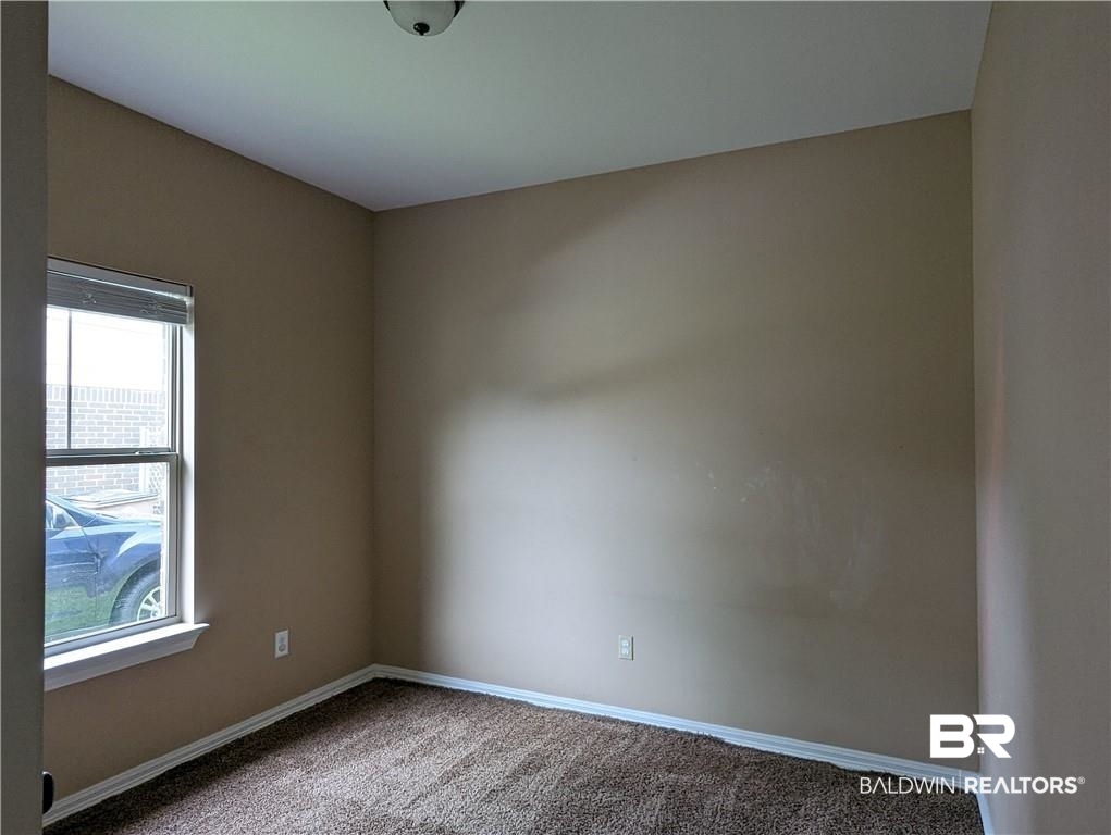 659 Bond Street Mobile, AL 36607 - Photo 5 of 10 Empty room with a healthy amount of sunlight and carpet flooring