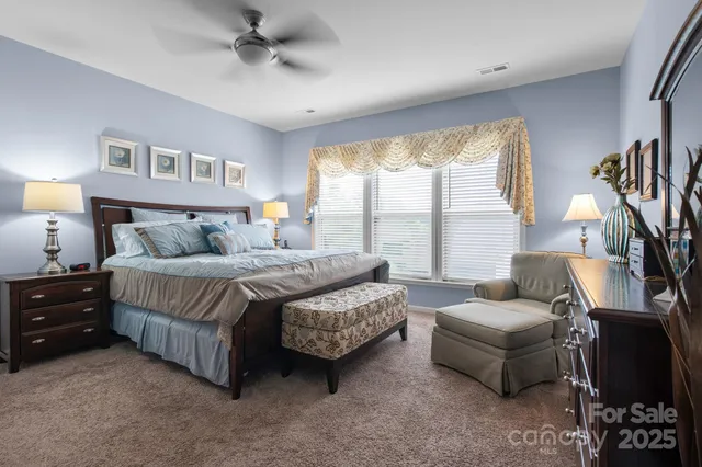 a bedroom with furniture and a large window