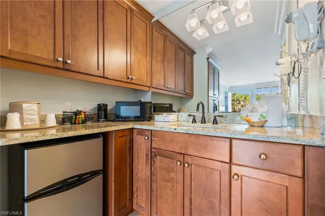 a kitchen with granite countertop stainless steel appliances a sink and cabinets