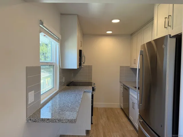 a kitchen with stainless steel appliances granite countertop a refrigerator and a sink