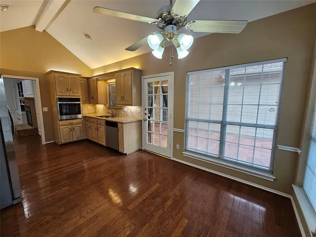 a view of a kitchen with a stove wooden cabinets and a dishwasher