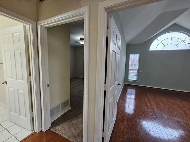 a view of a hallway with wooden floor and closet