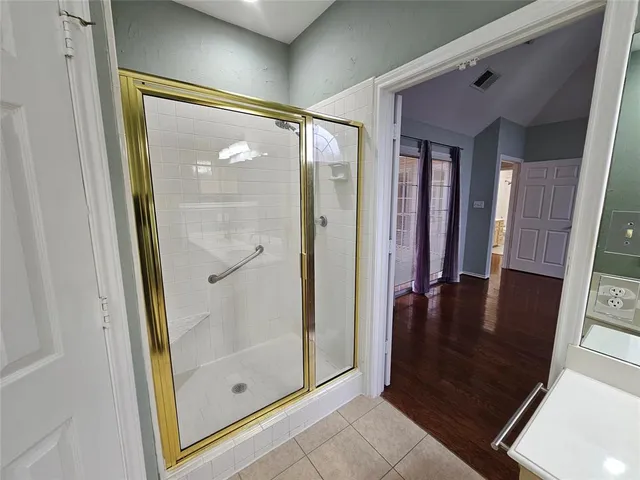 a bathroom with a glass shower door and a glass door