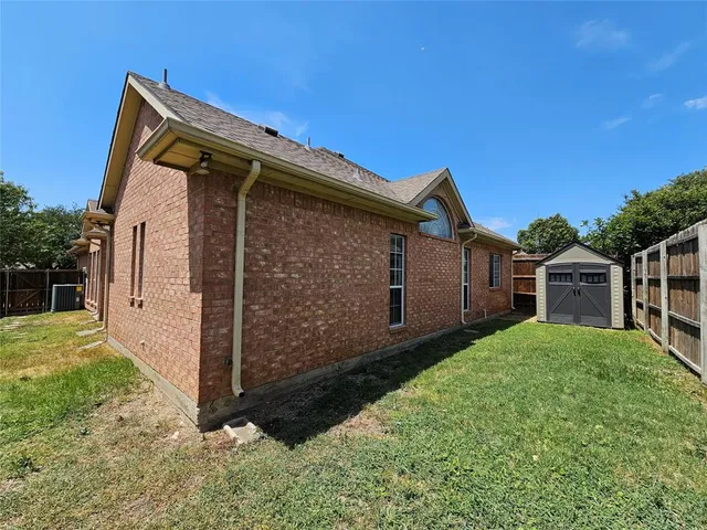 a view of backyard with potted plants and a wooden fence