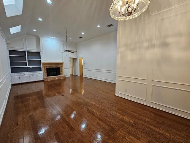an entryway and an empty room with wooden floor