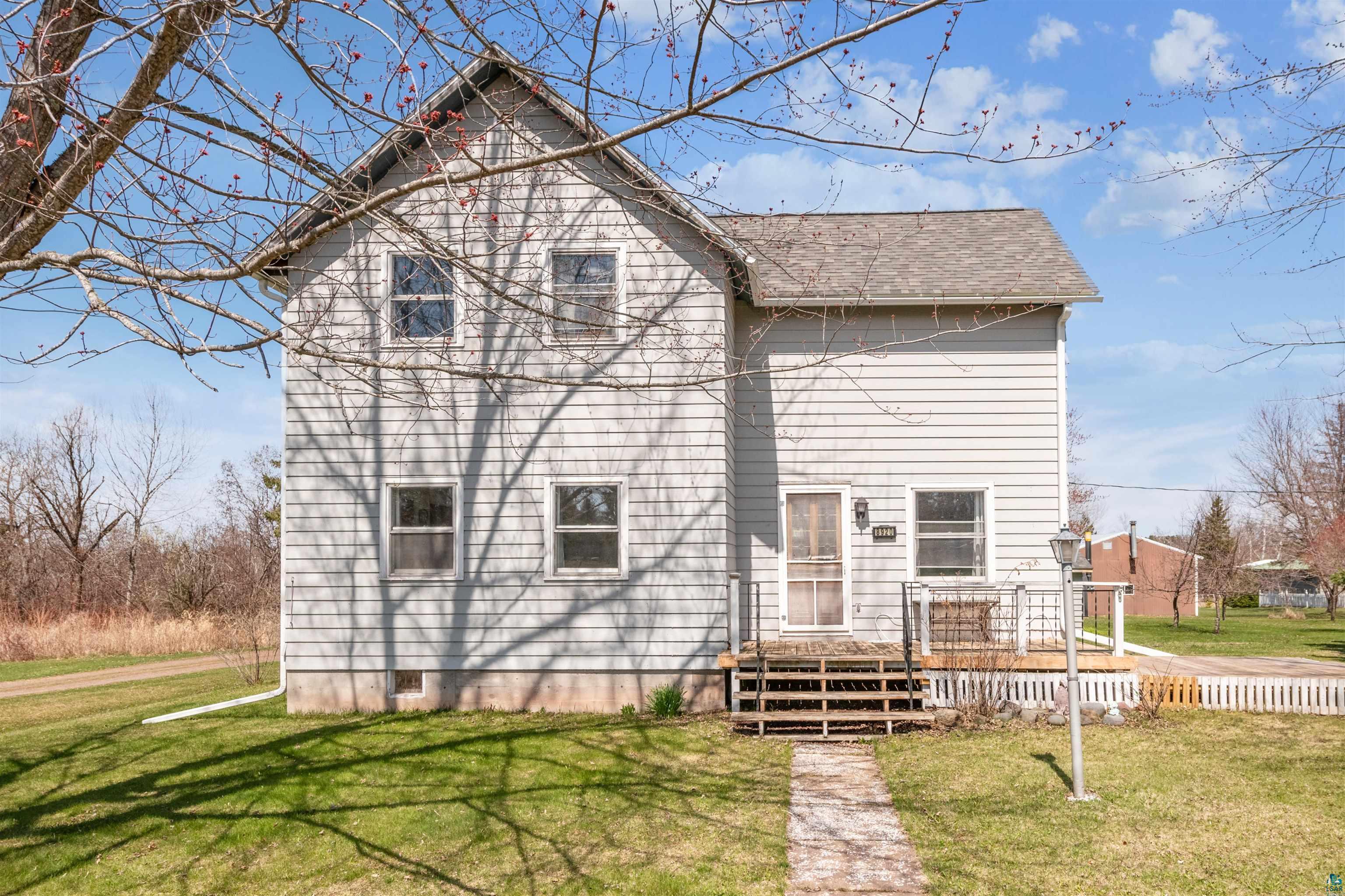 Back of property with a lawn, roof with shingles, and a deck