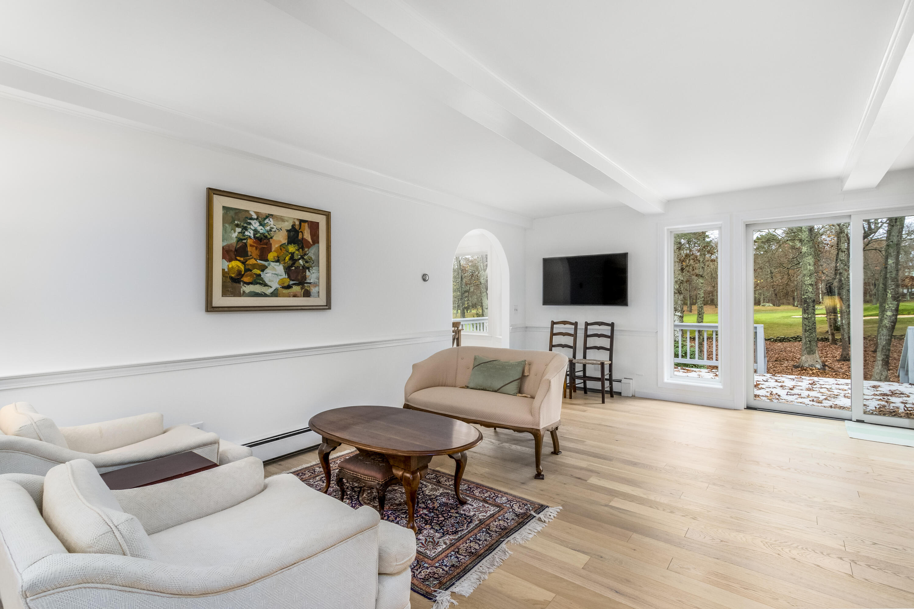 189 Dromoland Lane Barnstable, MA 02630 - Photo 4 of 40 a living room with furniture a flat screen tv and a floor to ceiling window