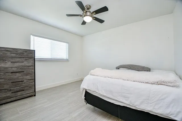 a bedroom with a bed and a ceiling fan
