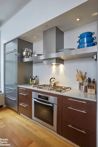 a kitchen with stainless steel appliances granite countertop a sink a stove and refrigerator
