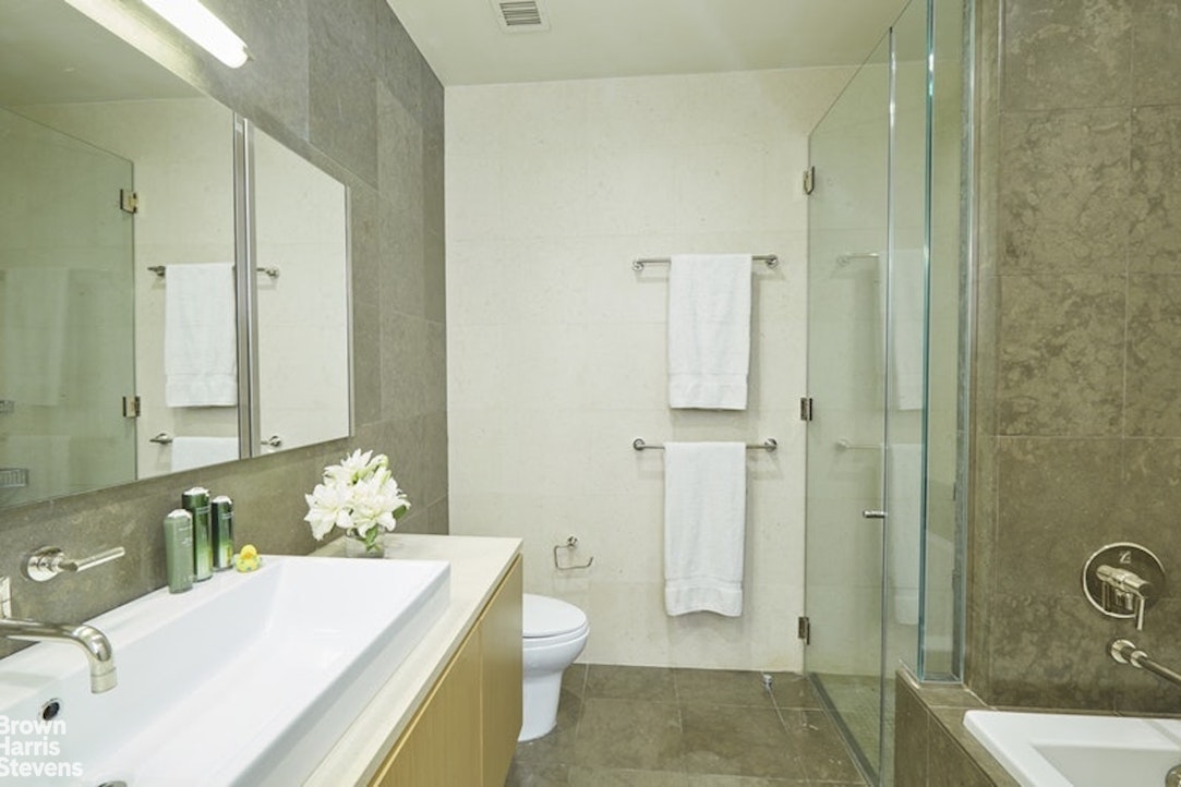 76 Madison Avenue, Unit 4A Manhattan, NY 10016 - Photo 7 of 19 a bathroom with a tub sink and mirror