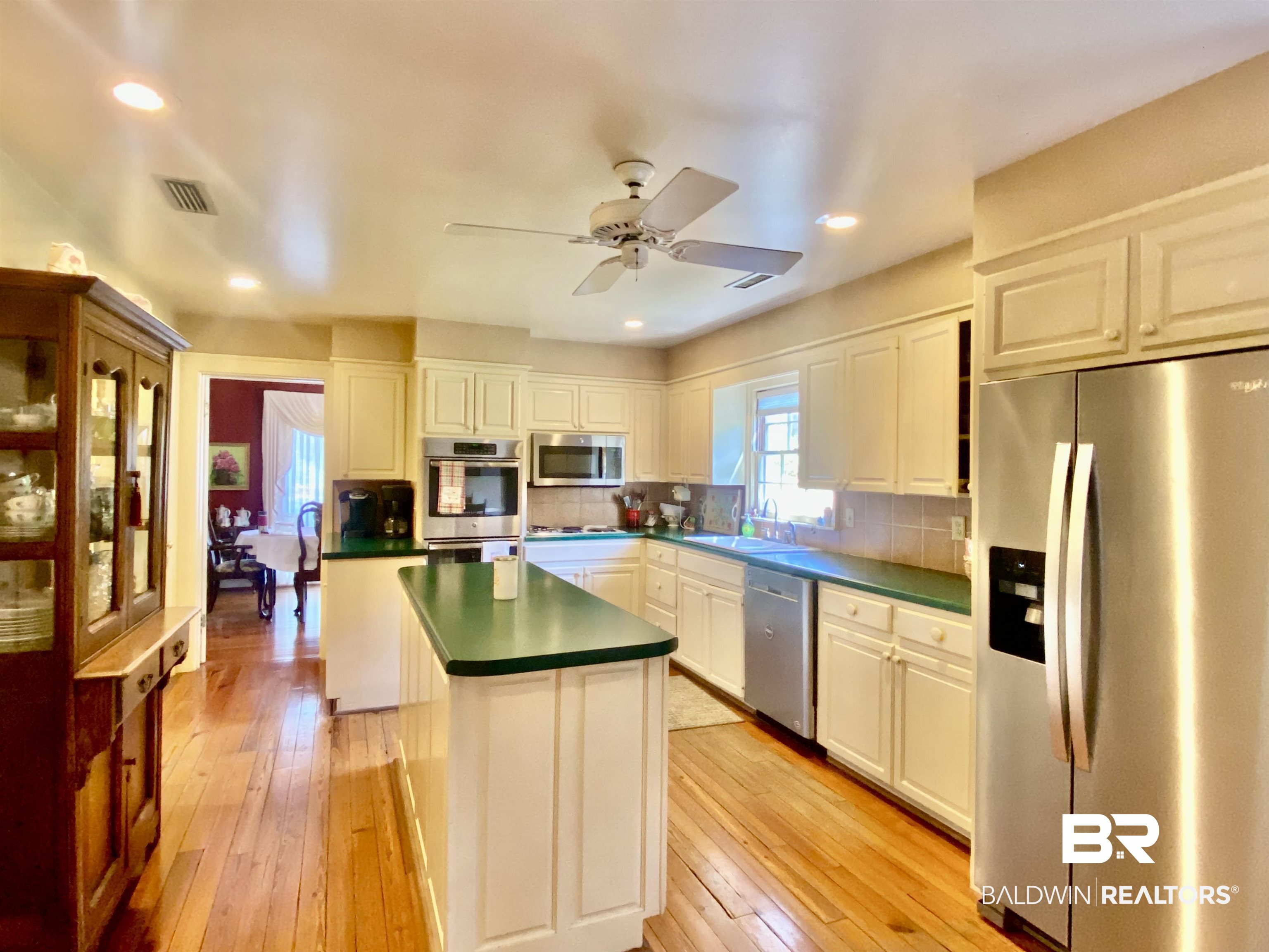 272 Longleaf Circle Monroeville, AL 36460 - Photo 10 of 38 Kitchen featuring ceiling fan, appliances with stainless steel finishes, backsplash, and white cabinetry.