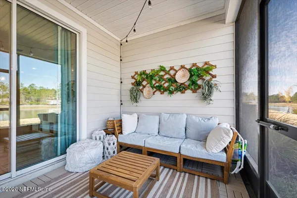 a balcony with wooden floor and outdoor seating
