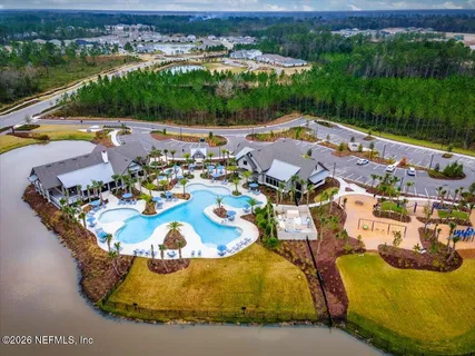 an aerial view of a house with swimming pool and lake view